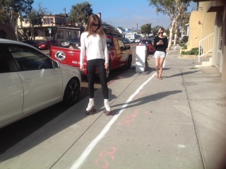 Sidewalk skater checks out sea-level-rise messages along the HWL.