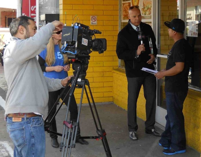 KPBS cameraman films Dwane Brown interviewing Mission Blvd. business owner.  