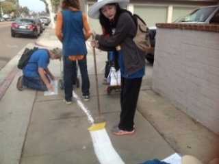 Rachel Eggers spreads and sets the chalk line with a broom.  