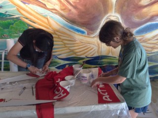 Khanh and Juliet carefully stenciling pennants.