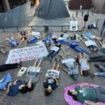 Activist laying down on the ground with signs