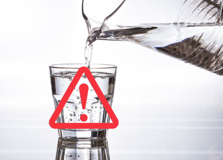 Pitcher pouring a glass of water with a caution symbol in front of it