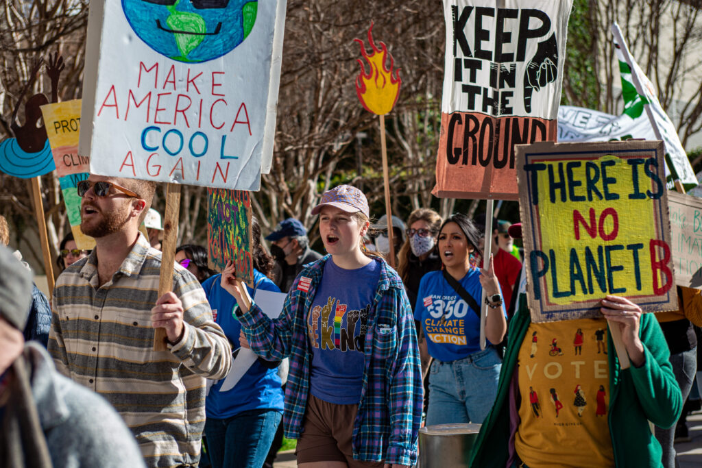 People marching in a rally holding signs.