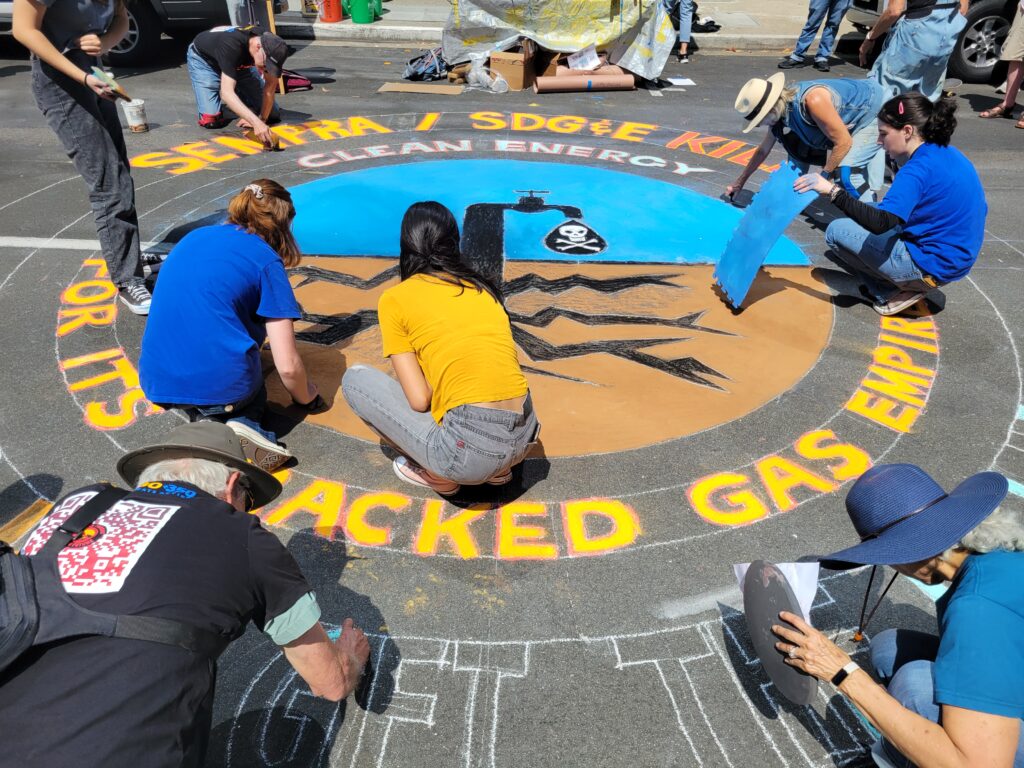 People working on street chalk art