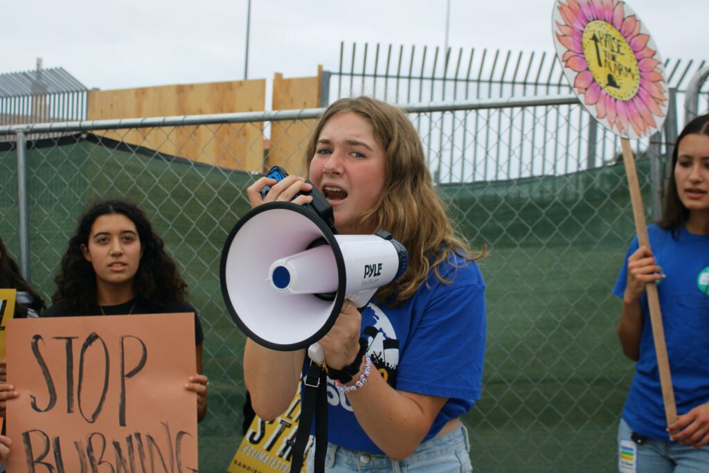 Emme Weibel chanting in a megaphone