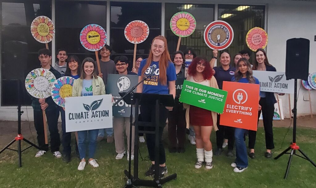 Lexi Rueff, SanDiego350's Chula Vista Youth Program Coordinator with a group of youth supporters holding signs.