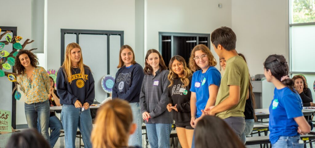 Youth students playing a game standing and smiling at eachother