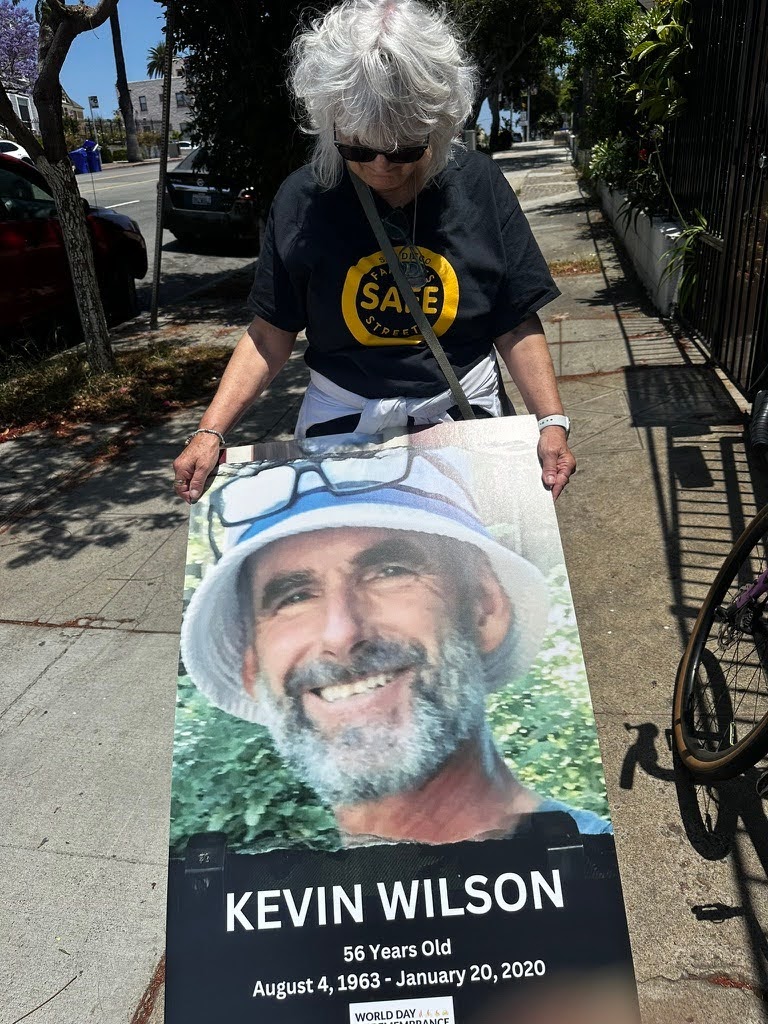 Nancy Wilson, holding the poster of her deceased husband, Kevin Wilson