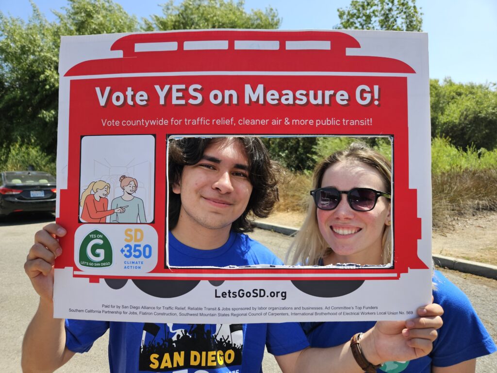 Daniel Hernandez, a high school youth, and McGarrah Wilson, SD350 staff member holding up a sign that reads "Vote YES on Measure G!"