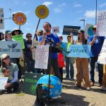 People with signs at a press conference