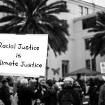 Sign at a protest that reads "Racial Justice is Climate Justice"