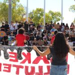 Youth member speaking to a stadium of students