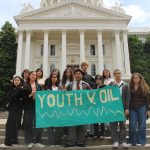 A group of youth standing in front of the CA state capital building holding a sign that reads " Youth v. Oil"