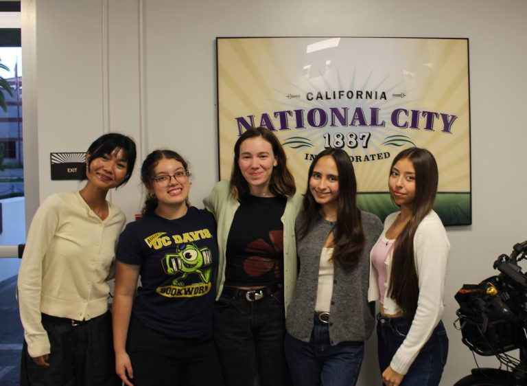 Youth smiling in front of a "National City" sign