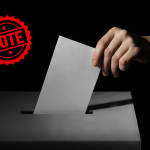 hand putting a ballot in the ballot box