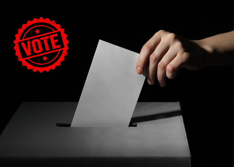 hand putting a ballot in the ballot box