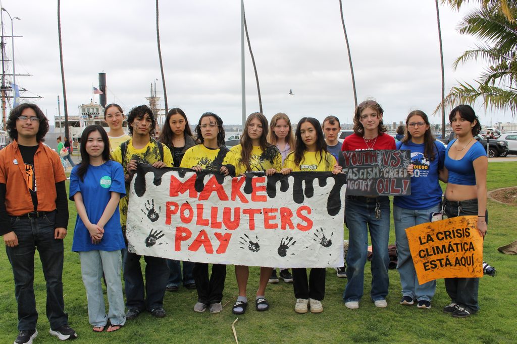 Youth holding a "make polluters pay" sign