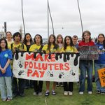 Youth holding a "make polluters pay" sign