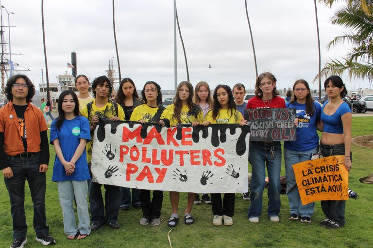 Youth holding a "make polluters pay" sign